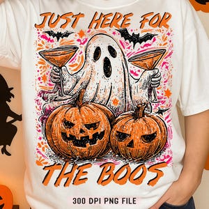 Könnte beinhalten: Weißes T-Shirt mit einem Halloween-Motiv. Das Design zeigt einen Geist mit Cocktails, zwei geschnitzte Kürbisse und Fledermäuse. Der Text auf dem Shirt lautet "JUST HERE FOR THE BOOS". Unten steht "300 DPI PNG FILE".