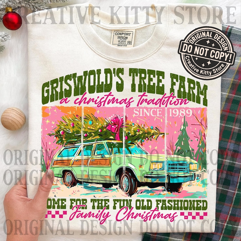 Puede incluir: Sudadera crema con un dise&ntilde;o gr&aacute;fico de un coche familiar verde con un &aacute;rbol de Navidad. El texto dice "Griswold's Tree Farm, a Christmas tradition since 1989". El dise&ntilde;o incluye detalles en rosa y verde, evocando un tema navide&ntilde;o vintage.