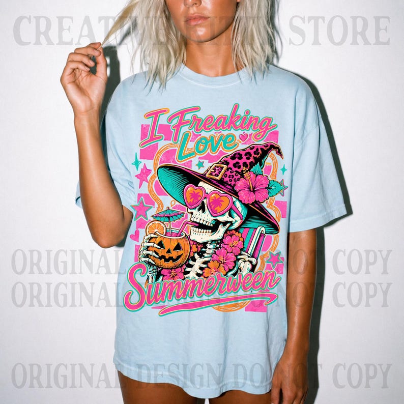 May include: A light blue t-shirt featuring a graphic of a skeleton wearing a leopard print witch hat and heart-shaped sunglasses. The skeleton holds a jack-o'-lantern drink with a straw. The text reads I Freaking Love Summerween.