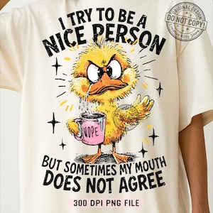 Pode incluir: Camiseta creme com um gráfico de um pato amarelo zangado segurando uma caneca rosa que diz "Nope". O texto acima diz "Eu tento ser uma pessoa legal" e abaixo, "Mas às vezes minha boca não concorda". O design inclui estrelas e raios de sol.