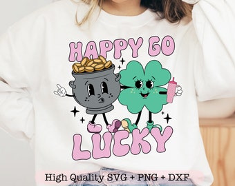 May include: A white sweatshirt with a pink and green graphic design. The design features a pot of gold with a smiling face and a four-leaf clover with a smiling face. The text "Happy Go Lucky" is written in pink letters.