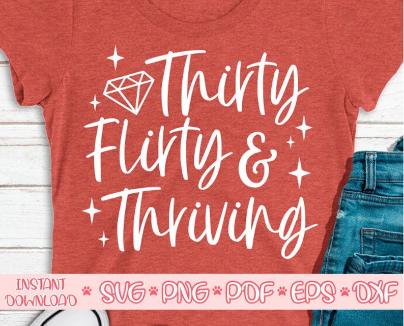 May include: Red t-shirt with white text that says "Thirty flirty & thriving" with a diamond graphic above the text.