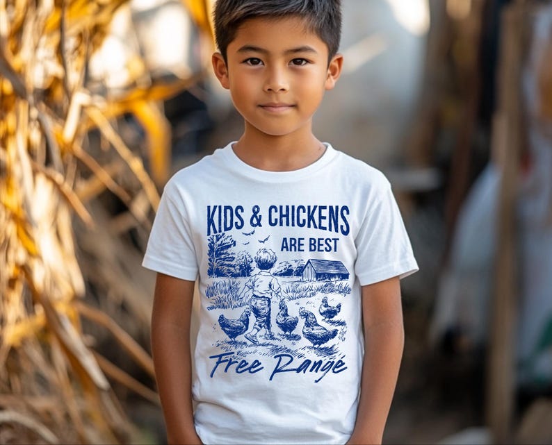 K&ouml;nnte beinhalten: Wei&szlig;es T-Shirt mit einer blauen Grafik eines Kindes und H&uuml;hnern. Die Grafik lautet "Kids & Chickens Are Best Free Range".