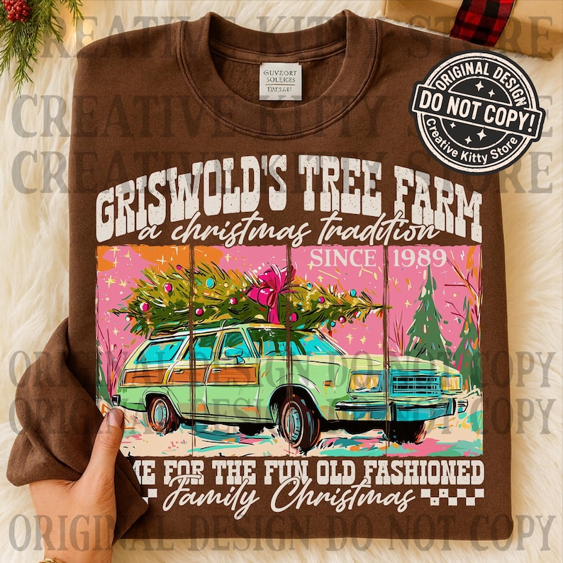 May include: Brown sweatshirt with a graphic of a green station wagon carrying a Christmas tree. The text reads "GRISWOLD'S TREE FARM a christmas tradition SINCE 1989" and "MAKE FOR THE FUN OLD FASHIONED Family Christmas". The design includes pink and green elements.