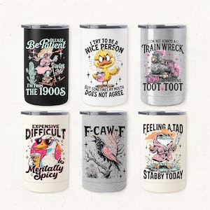 May include: Six stainless steel travel mugs with humorous illustrations and text. Designs include a woman with a cactus, a chick with a coffee cup, a train, a duck with sunglasses, a raven, and a frog with a knife. Each mug has a different design.