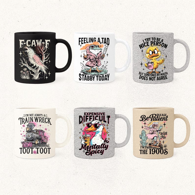 May include: Six ceramic mugs with humorous designs. The mugs feature various graphics and text, including a crow, a frog with a knife, a duck, a train, a duck with sunglasses, and a person on a scooter. Each mug has a different color and design.