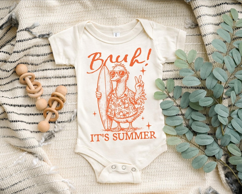 May include: A white baby onesie with an orange graphic of a cartoon bird wearing sunglasses and a floral shirt, holding a surfboard. The text "Bruh! It's Summer" is printed below the bird.