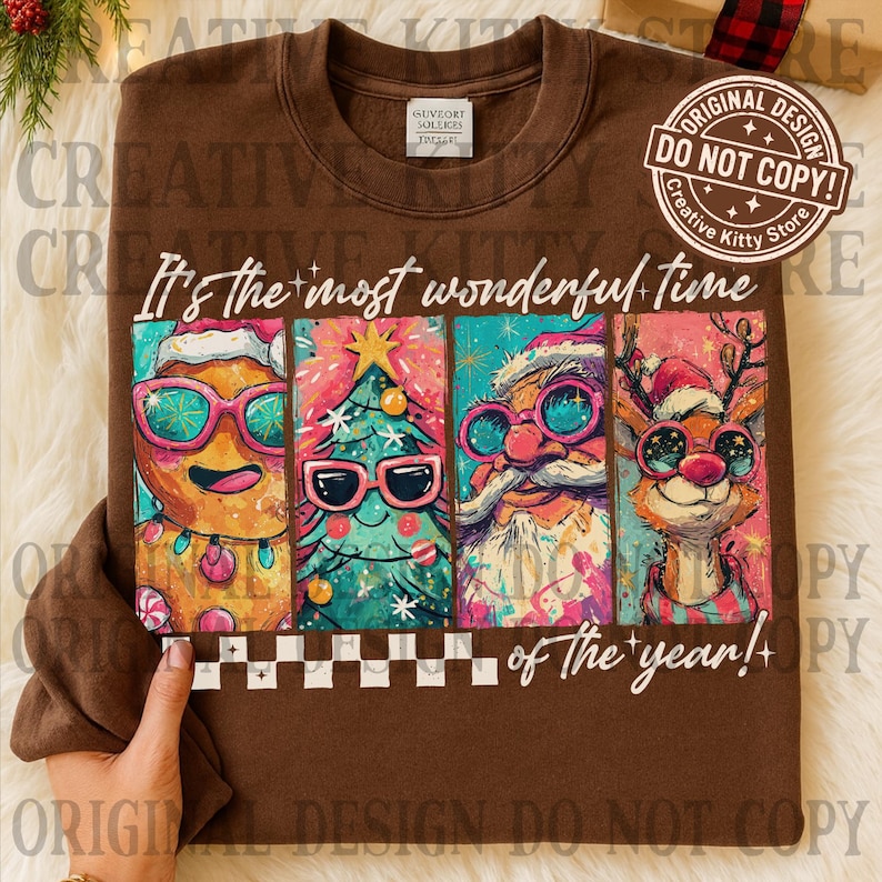 May include: Brown sweatshirt with a colorful graphic featuring a gingerbread man, Christmas tree, Santa Claus, and reindeer, all wearing sunglasses. The text reads "It's the most wonderful time of the year!"