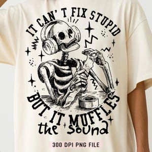 May include: Cream-colored t-shirt with a black graphic of a skeleton wearing headphones and using tape. The text reads "IT CAN'T FIX STUPID BUT IT MUFFLES the SOUND." Below the graphic is "300 DPI PNG FILE."