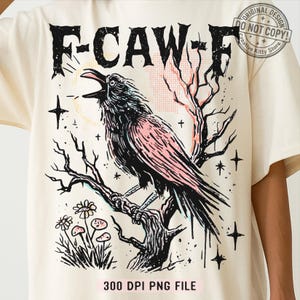 May include: Cream-colored t-shirt featuring a black crow perched on a tree branch, with the text "F-CAW-F" above. The crow has pink accents, and the design includes stars, flowers, and the text "300 DPI PNG FILE".