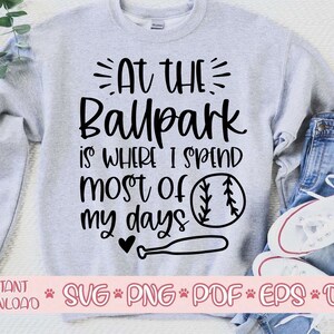 May include: A gray sweatshirt with the text "At the Ballpark is where I spend most of my days" and a baseball graphic. The text is in black and the baseball is black and white.