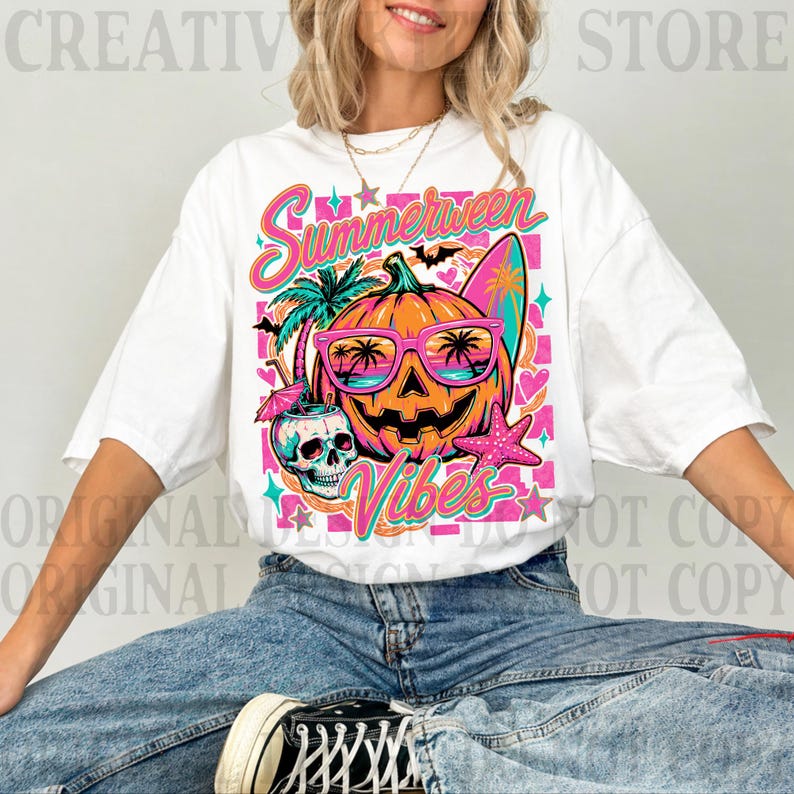 May include: A white short-sleeve t-shirt featuring a colorful graphic print of a jack-o'-lantern wearing pink sunglasses, a skull with a cocktail, a surfboard, a palm tree, and a starfish, with the text Summerween Vibes in pink and teal.