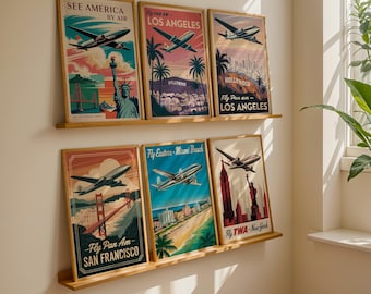 Puede incluir: Una colección de carteles de viaje vintage enmarcados con ilustraciones de aviones. Los carteles representan lugares emblemáticos de Estados Unidos, como Nueva York, San Francisco y Miami Beach. La paleta de colores incluye azules, rojos y naranjas.