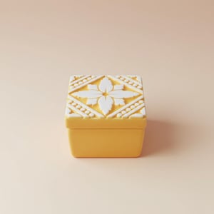 Könnte beinhalten: Eine quadratische, gelbe Schmuckschatulle mit einem weißen Blumendesign auf dem Deckel. Der Deckel hat ein erhabenes, symmetrisches Muster mit einer zentralen Blume und geometrischen Formen. Die Box ist einfarbig gelb.