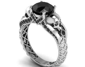 May include: A silver ring with a black skull design and a large black gemstone. The ring is set with smaller black gemstones around the skull and gemstone.