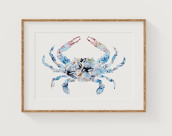 May include: A framed watercolor print of a crab. The crab is composed of blue, white, and floral patterns. The claws are red and pink. The artwork is set against a white background and framed in a light brown wooden frame.