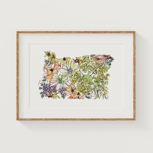 May include: A framed art print featuring a floral arrangement in the shape of the state of Oregon. The artwork showcases a variety of flowers in shades of yellow, orange, pink, and purple, outlined with black ink. The frame is a light brown color.