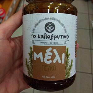 Könnte beinhalten: Ein Glas Honig aus Kiefern mit einem braunen Etikett, auf dem "Το καλαβρυτινό" in Griechisch steht, was "Der Kalavryta Honig" bedeutet. Das Etikett trägt außerdem die Aufschrift "ΓΚΛΑΒΑΣ Γ. ΣΩΤΗΡΙΟΣ" und "Μέλι Πεύκο" in Griechisch, was "GLAVAS G. SOTIRIOS" und "Kiefern Honig" bedeutet. Das Glas hat ein Gewicht von 450 Gramm.