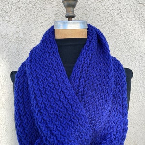 May include: A royal blue knitted infinity scarf with a textured pattern.