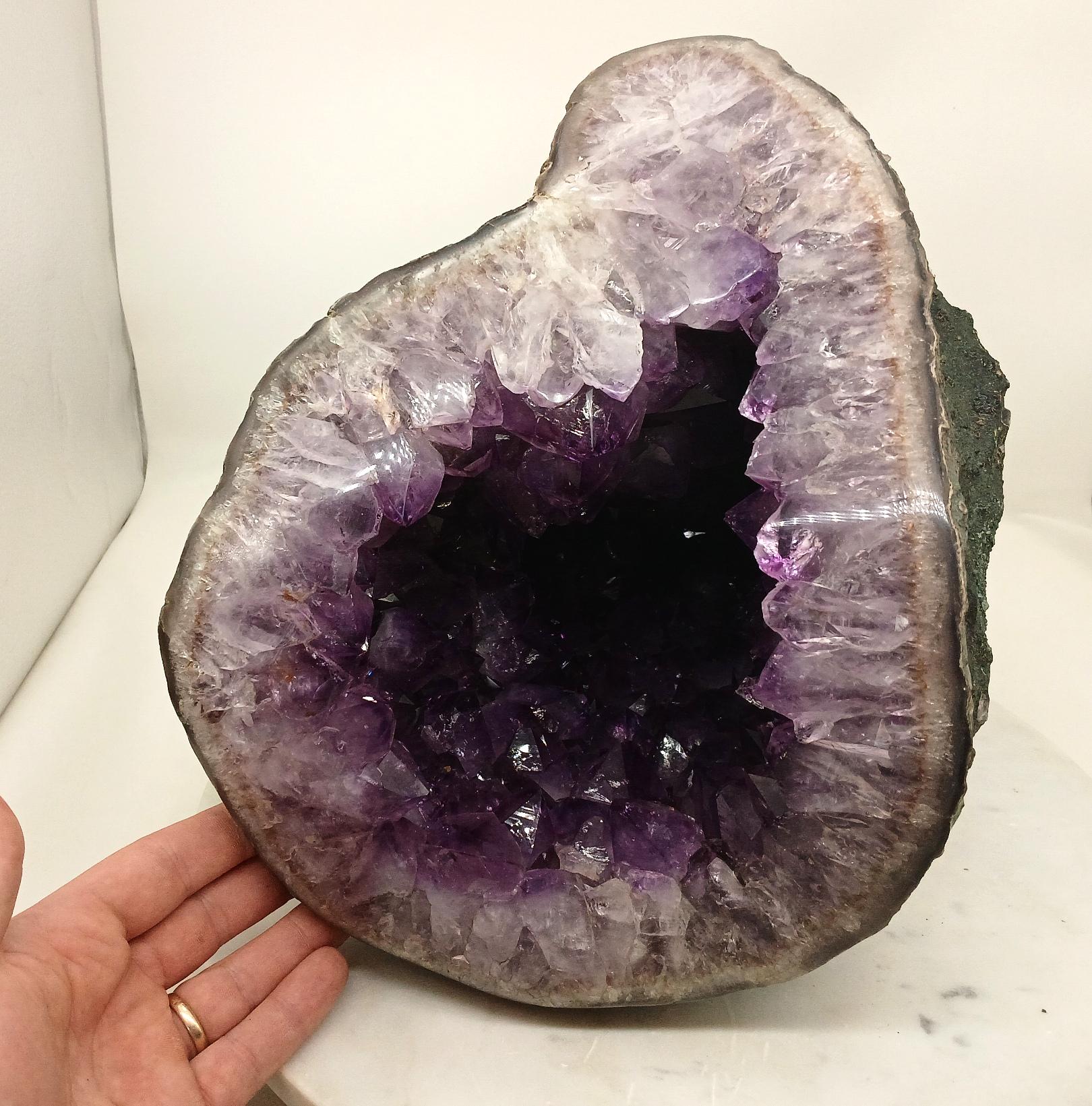 A geode split open to reveal purple amethyst crystals inside