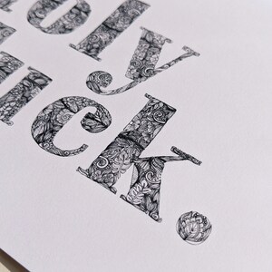 May include: A close-up of the word "lucky" written in a decorative font. Each letter is filled with intricate black and white patterns.