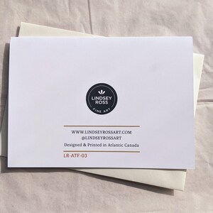 May include: A white card with black text and a black logo that says "Lindsey Ross Fine Art". The text on the card reads "www.lindseyrossart.com @lindseyrossart Designed & Printed in Atlantic Canada LR-ATF-03"