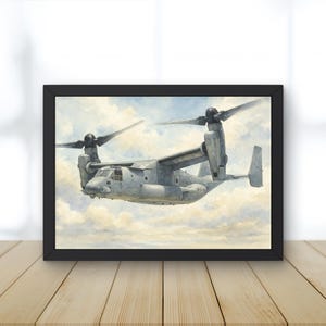 Puede incluir: Una impresión enmarcada de un avión militar gris con dos grandes hélices, sobre un cielo nublado. El avión está en pleno vuelo, con sus alas y cola claramente visibles. El marco es negro y la obra de arte se exhibe sobre una superficie de madera.