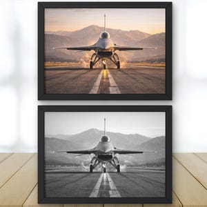 May include: Two framed prints of a jet fighter on a runway. The top print is in color, showing the jet with mountains in the background. The bottom print is a black and white version of the same image.