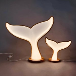A composition of two unusual lamps in the shape of a whale&#39;s tail from | A lamp in the form of the tails of a baby whale and its mother.