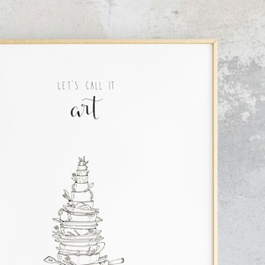 May include: A white framed print with black text that reads "Let's call it art."  A black and white illustration of a stack of dishes, cups, and utensils is below the text.