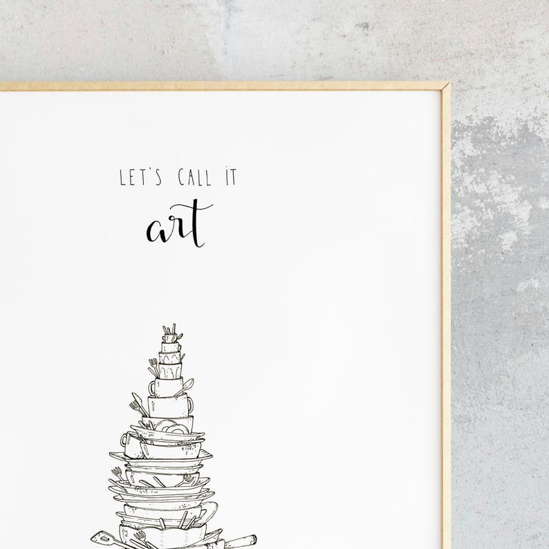 May include: A white framed print with black text that reads "Let's call it art."  A black and white illustration of a stack of dishes, cups, and utensils is below the text.