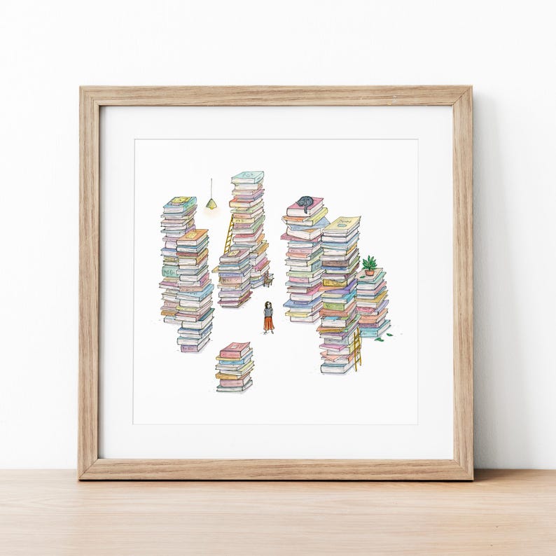 Op de afbeelding: Een aquarel illustratie van een persoon die voor een grote stapel boeken staat. De boeken zijn gestapeld in verschillende kleuren en maten, en er staat een klein plantje op een van de stapels. De illustratie is ingelijst in een licht houten lijst.
