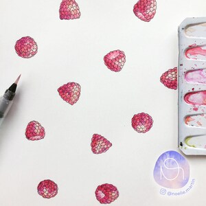 Puede incluir: Una hoja de papel blanca con un patr&oacute;n de acuarela de frambuesas rosas. Las frambuesas est&aacute;n pintadas en un estilo realista con diferentes tonos de rosa y rojo. Una paleta de acuarela con pintura rosa y roja es visible en la esquina superior derecha de la imagen.