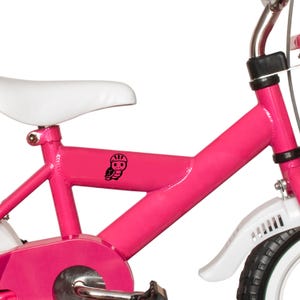 Puede incluir: Una bicicleta rosa brillante para ni&ntilde;os con un sill&iacute;n y guardabarros blancos. Una tortuga de dibujos animados negra con casco est&aacute; en el cuadro. El manillar es plateado y los neum&aacute;ticos son negros con laterales blancos.