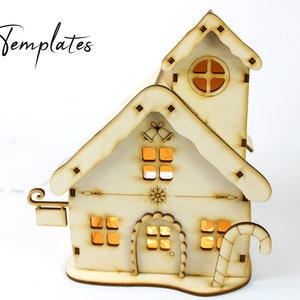 Puede incluir: Una casa de Navidad de madera con un bast&oacute;n de caramelo, una campana y un dise&ntilde;o de copo de nieve. La casa tiene una luz en el interior, lo que la hace brillar.