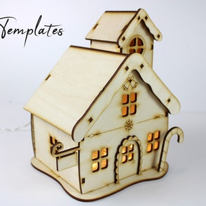 Puede incluir: Una casa de Navidad de madera con un bast&oacute;n de caramelo, campanas y un dise&ntilde;o de copo de nieve. La casa tiene luces en el interior y est&aacute; hecha de madera sin terminar.