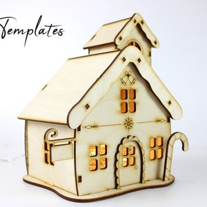 Puede incluir: Una casa de Navidad de madera con un dise&ntilde;o de bast&oacute;n de caramelo, copo de nieve y campana. La casa tiene ventanas con luces en el interior.