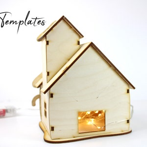 Puede incluir: Una casa de madera con un acabado marr&oacute;n claro y una ventana con luces de cadena en el interior. La casa es un proyecto de artesan&iacute;a de bricolaje y est&aacute; lista para ser ensamblada.