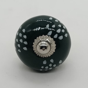 May include: A dark green ceramic knob with a white speckled pattern and a silver metal center.