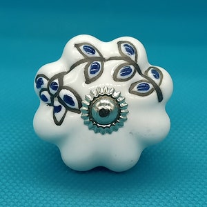 May include: White ceramic cabinet knob with a blue and silver floral design.