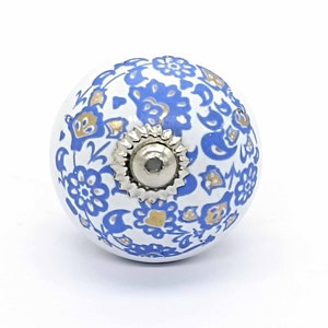 May include: White ceramic knob with a blue and gold floral pattern. The knob has a silver metal base.