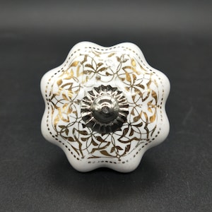 May include: White ceramic cabinet knob with a gold and silver floral design.