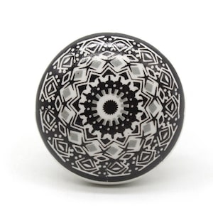 Puede incluir: Pomo de cerámica negro y blanco con un diseño de mandala. El pomo es redondo y tiene un diseño en relieve.