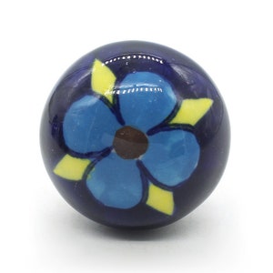 May include: A blue ceramic knob with a yellow and blue flower design.