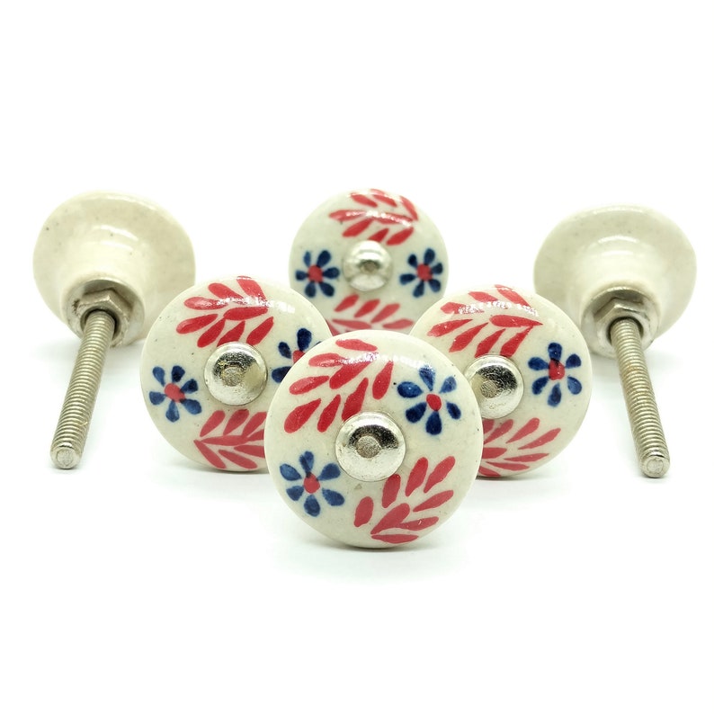 May include: Five white ceramic knobs with red and blue floral designs. The knobs have a silver screw and are perfect for adding a touch of farmhouse style to your home decor.