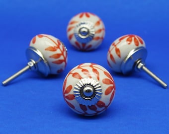 May include: Four white ceramic cabinet knobs with red leaf designs and silver accents.