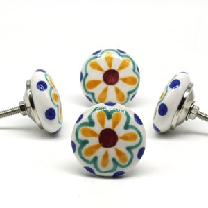 May include: Four ceramic cabinet knobs with a white background and a colorful floral design. The knobs have a silver screw on the back.