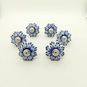 May include: Six blue and white ceramic flower-shaped drawer knobs with silver accents.