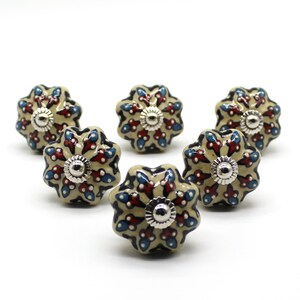 Könnte beinhalten: Sechs Keramik-Schrankknöpfe mit einem floralen Design in Blau-, Rot- und Weißtönen. Die Knöpfe haben eine silberne Oberfläche und sind perfekt, um jedem Raum einen Hauch von Eleganz zu verleihen.