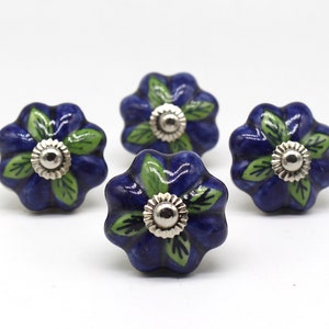 May include: Four blue ceramic flower-shaped knobs with green leaves and silver centers. These knobs are perfect for adding a touch of farmhouse charm to your kitchen cabinets or drawers.